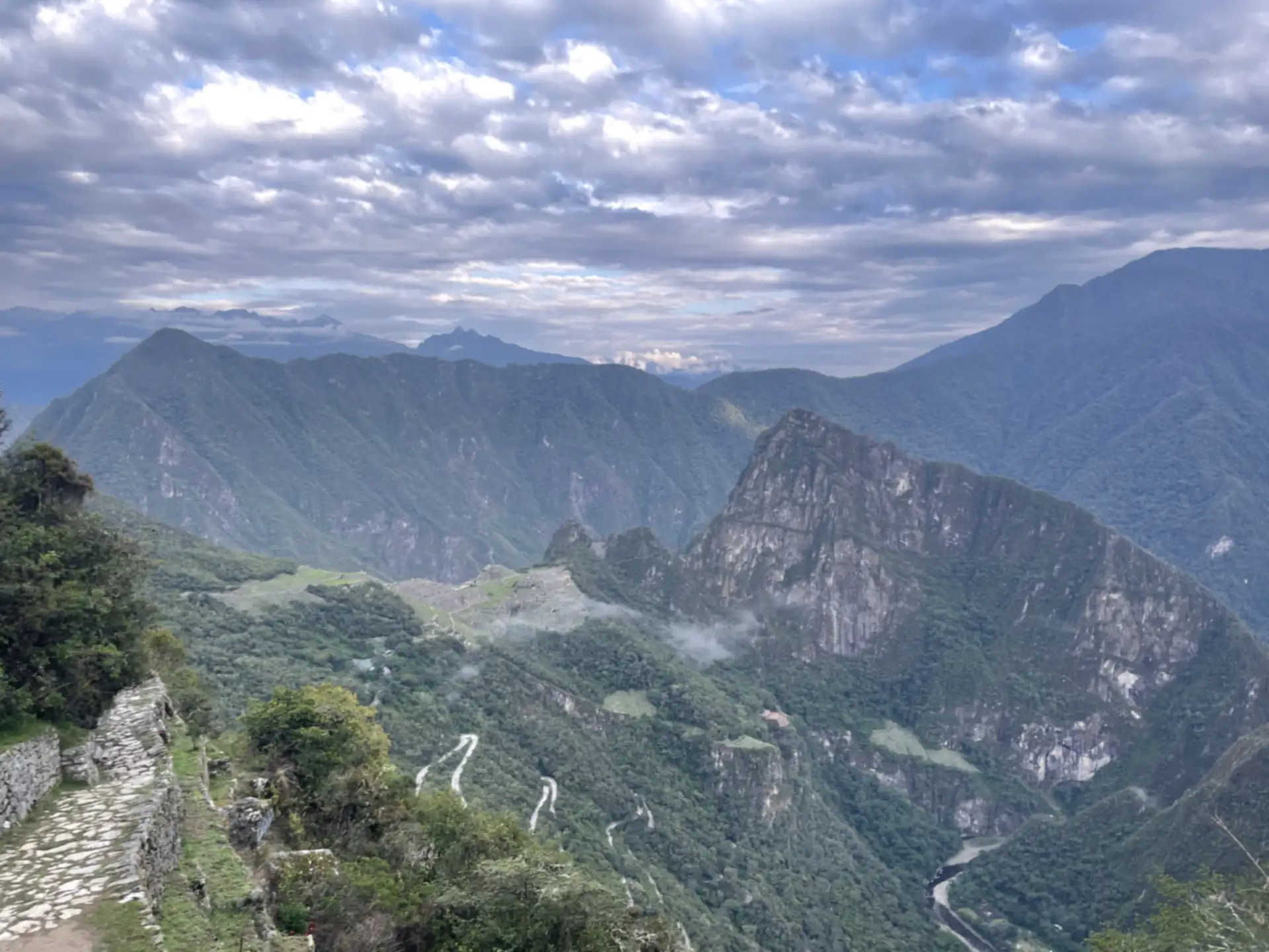 The stone Inca Trail near the Sun Gate, with Machu Picchu and Huayna Picchu in the valley below