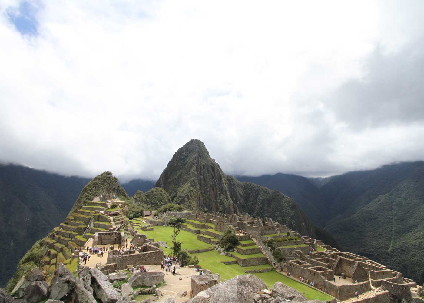 Machu Picchu citadel terraces beneath Huayna Picchu peak, wrapped in morning mist