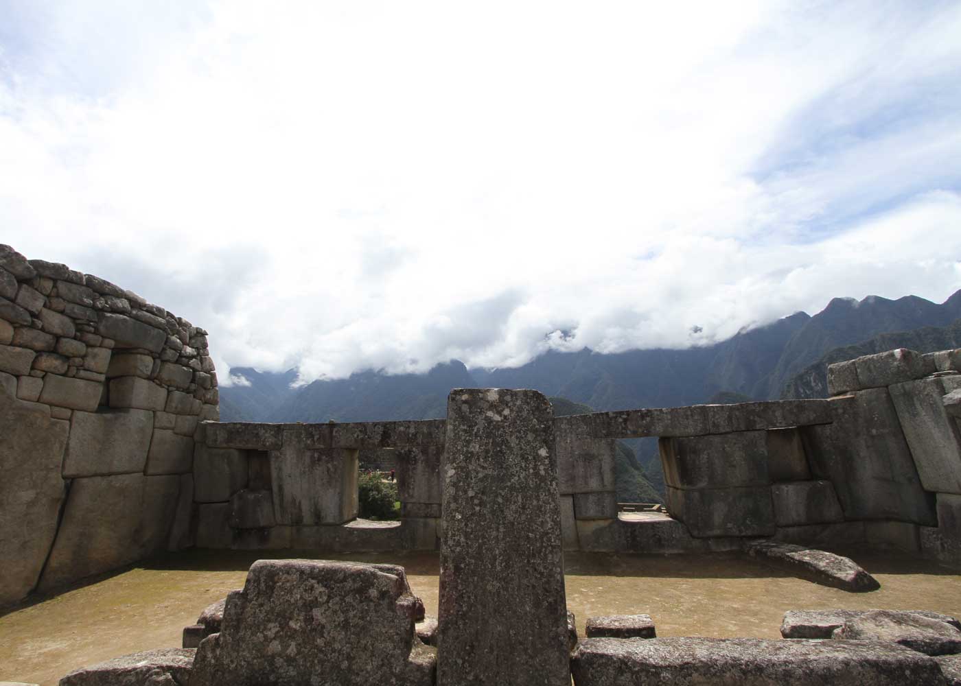 Ancient Inca stonework at Machu Picchu framing misty Andean peaks