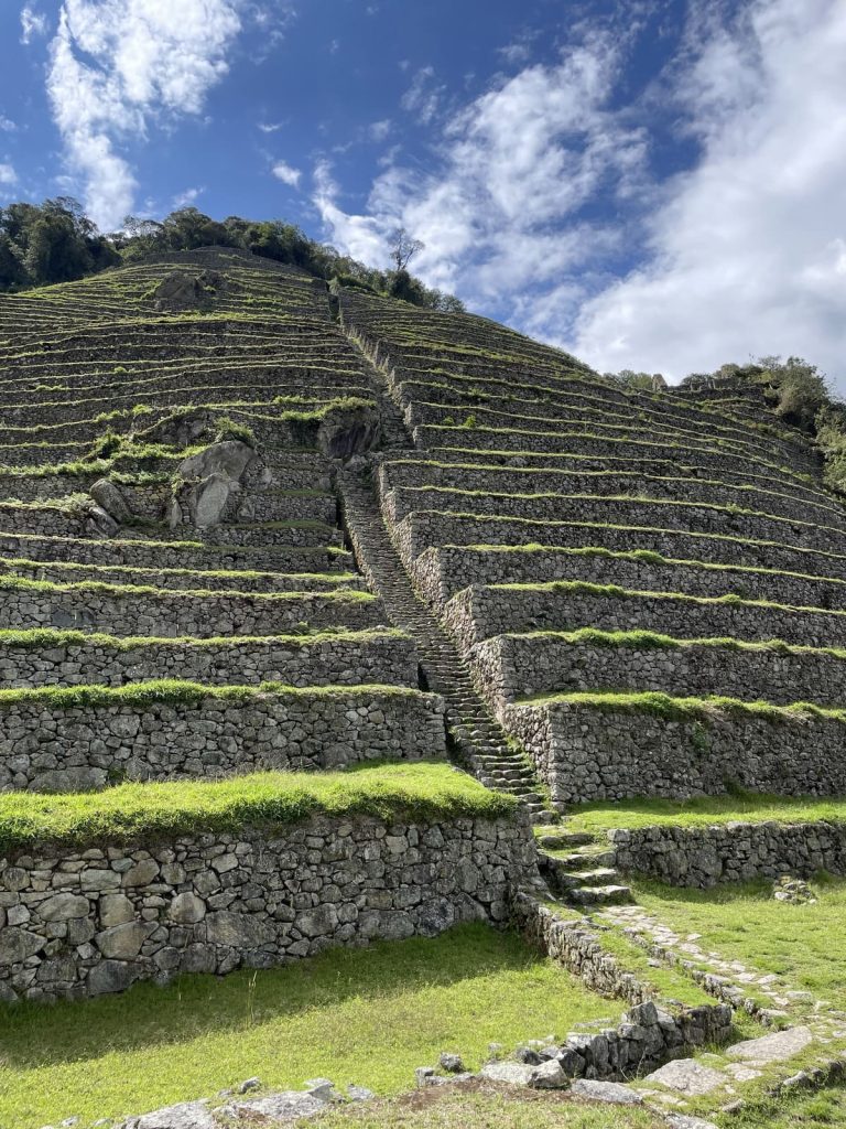 Steep Inca stone terraces with a staircase climbing through them at Intipata