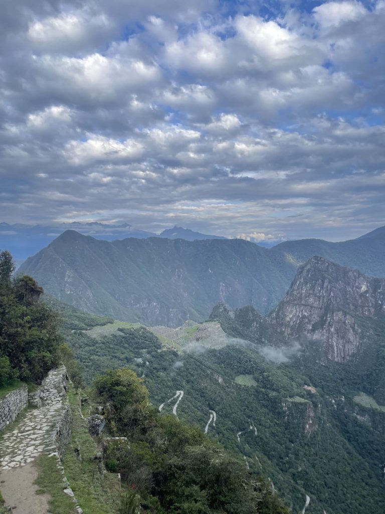 Machu Picchu seen from the Sun Gate, with the zigzag bus road climbing the mountainside below it