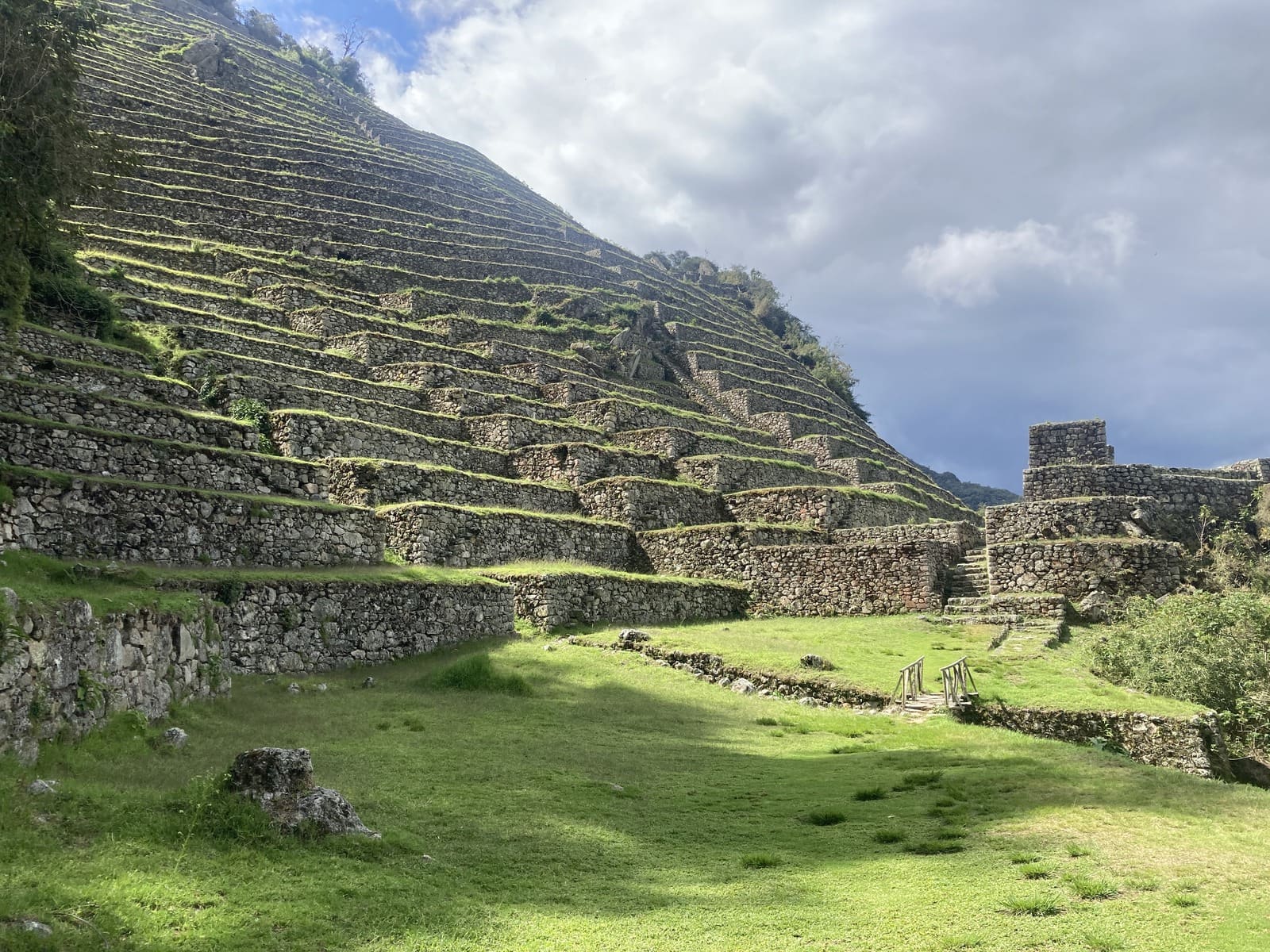 Broad grassy terraces and stone walls at Intipata, near Wiñay Wayna