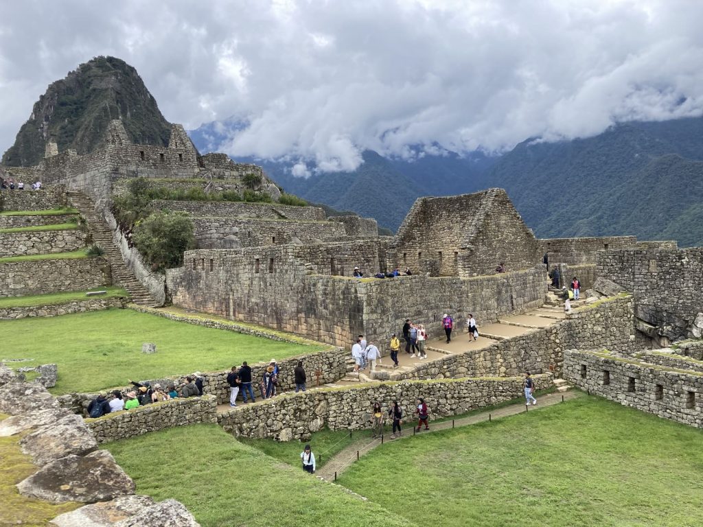 Visitors crossing the main plaza of Machu Picchu below Huayna Picchu